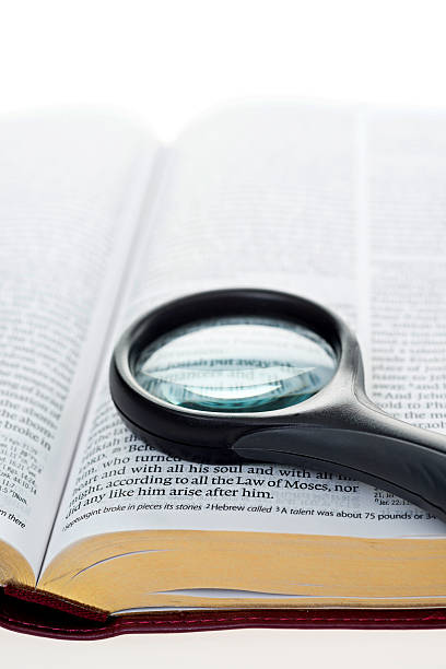 Openning book with a magnifying glass on it.